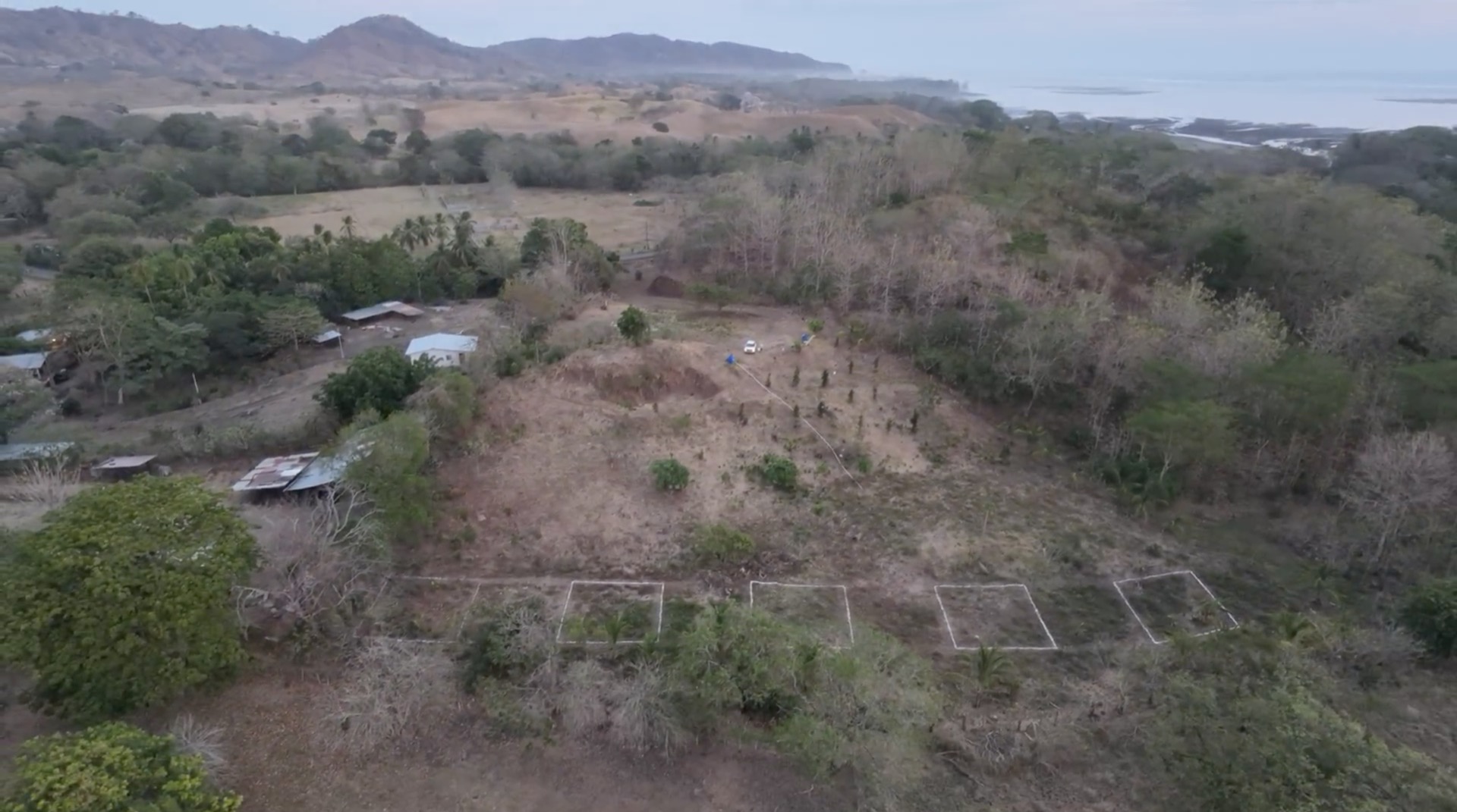 Aerial of the land with surveyed plots, mountains and ocean